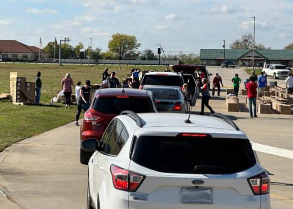 After winding through the Sulphur Springs High School parking lot, a single vehicle line goes through the food distribution area. Staff photo by Enola Gay Mathews