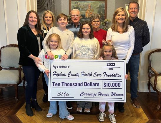Hopkins County Health Care Foundation expressed thanks to Carriage House Manor for sponsoring the 18th annual Gala! Arvis and Sheila Tanton (back center) are joined by their daughters, Sharla Campbell (left) and Shandra Dunn (second from left), and grandchildren for a check presentation to Gala Chairs Kim and John Sellers (right). Visit LOLGala2024.GiveSmart.com for more information. HCHC Foundation Photos
