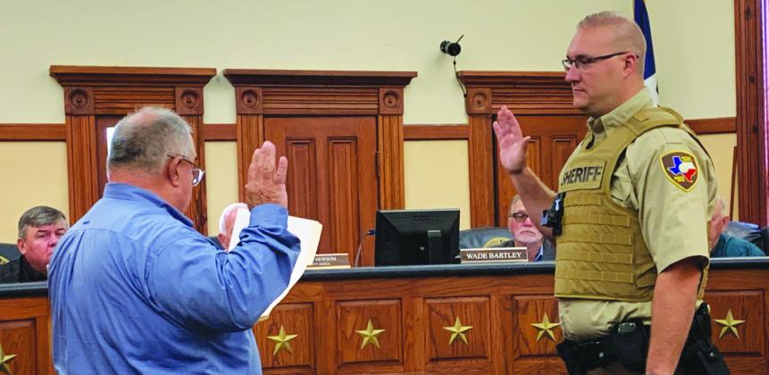 Hopkins County Sheriff Lewis Tatum administers the oath of office for deputy sheriff to Mark Holcomb during Hopkins County Commissioners Court Monday, Oct. 23.