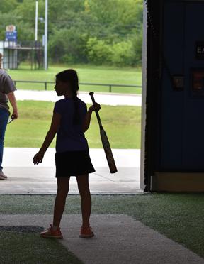 A camper prepares for her turn at bat during a game held at the end of day two of camp. Approximately 50 players attended the two sessions of the annual camp: one for athletes in first-fifth grades and one for those entering fifth-ninth grades.