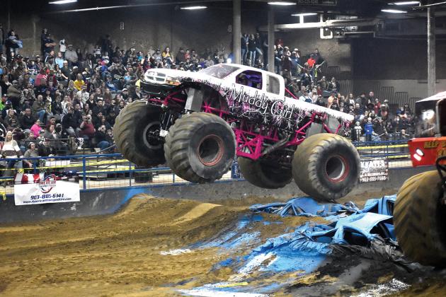 “Muddy Girl,” driven by Maddie Breaud of Windsor, Pennsylvania, makes a flying run over obstacles in front of a standing-room-only crowd at Hopkins County Regional Civic Center Arena during the Monster Truck Rally exposition held Saturday night and presented by Xtreme Monster Sports, Inc. The truck has a 536 Merlin engine with 1,450 horsepower, Powerglide transmission and BKT tires. Staff photo by Jillian Smith