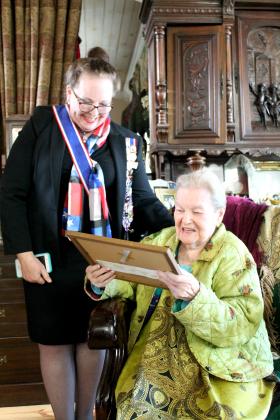 Ruth Allen (seated) admires her framed certificate from the Daughters of the Republic of Texas, given to her by Carolyn Thomas Raney (standing). Allen will also receive a commemorative medallion on her headstone. Staff photo by Taylor Nye