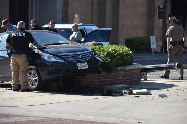 The car crashed into a planter box, streetlight and stop sign at the intersections of College, Oak and Main streets.