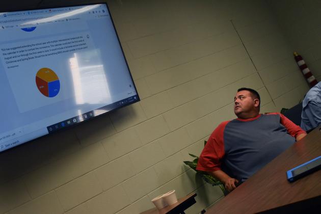 Sulphur Bluff ISD school board member Chris Bassham peers at the screen, which shows results from a survey done by the district, during the regular meeting Thursday night. Staff photo by Todd Kleiboer