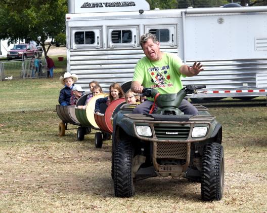 Darris Cross of Como drives little ones around in his barrel train ride on the Hopkins County Civic Center grounds Saturday as part of the Fall Festival. Staff photo by Todd Kleiboer