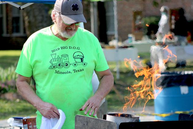 Colley Jones of Mineola fires up his coals in preparation for the annual John Chester Dutch Oven Cook-off held at Heritage Park Saturday with Indian Summer Days. Staff photo by Jillian Smith