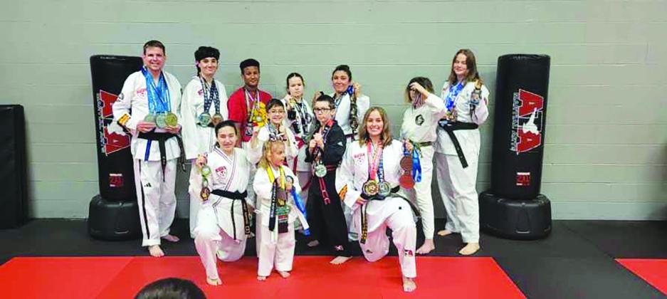 HONORS EARNED — Members of the Sulphur Springs American Taekwondoe Association (ATA) performed well at the South USA District Championships in Allen. Pictured are: Front row, left to right: Haley Hopkins, Noah Perry, Olivia Stegient, Ethan Calhoun, and Harleigh Stegient. Back row, left to right: Daron Bilyeu, Seth McElyea, Gaius Hanna, Summer Miller, Sam Perry, Scarlett Allen, and Karisma Stegient. Submitted Photo