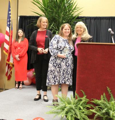 Lyndie Mansfield accepts the Growth and Renewal Award presented by Sulphur Springs Downtown Business Alliance's Marlene DeYoung and Enola Gay Mathews to Main Street Theatre.