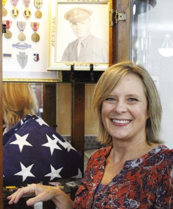 Hope Cain, Director of the Sulphur Springs Public Library stands among a portrait of Buddy Sinclair and the WWII memorabilia Sinclair and his wife donated to the library. Cain has big plans to make the existing display into a larger exhibit, focusing on Sinclair and his wife, Katie’s story during his deployment to Italy during“Operation Avalanche.”