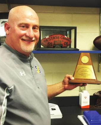 Greg Owens shows off a copy of the 2008 4A State Championship football trophy. Staff photo by Don Wallace