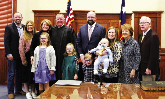 John Ginn, Hopkins Couty Court at Law Judge, stands with his family following his swearing-in ceremony at the Hopkins County Courthouse Tuesday, Jan. 2. From left are: Andy Ginn and wife Stephanie; wife Eydie McDowell Ginn; granddaughter Caroline; Ginn; granddaughter Scarlet; son Charlie McDowell; son Caleb; wife Catherine and grandson Carson; mother-in-law Charlotte McDowell and father-in-law and partner William McDowell. Staff photo by Tammy Vinson