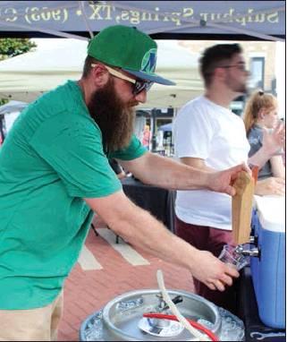 BackStory Brewery brewmaster Grayson Wing samples a beer at the 2019 Red, Whites and Brew festival held on Celebration Plaza in Sulphur Springs Saturday. Staff photo by Taylor Nye