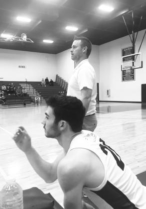 Parker Whisenhunt (20) and head coach Brandon Shaver watch the game from the sideline. Staff photo by Don Wallace