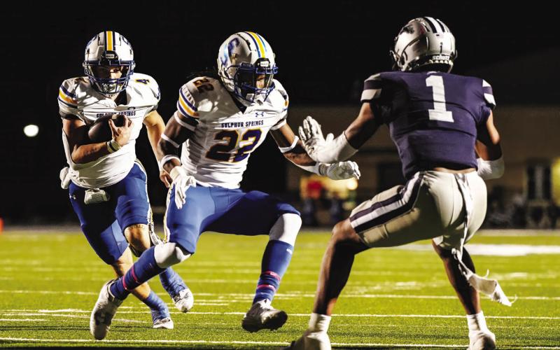 SCORING RUN — Brady Driver (4) follows behind a block of Cameron Jefferson (22) on his way to the end zone during the Wildcats' game against Paris Friday. Driver completed five of nine passes for 59 yards, throwing one touchdown and one interception, though his biggest impact was on the ground, as he rushed for a team-high 163 yards on 23 carries and scored four touchdowns in the Wildcats' 37-30 victory. Photo by Dinh Tran