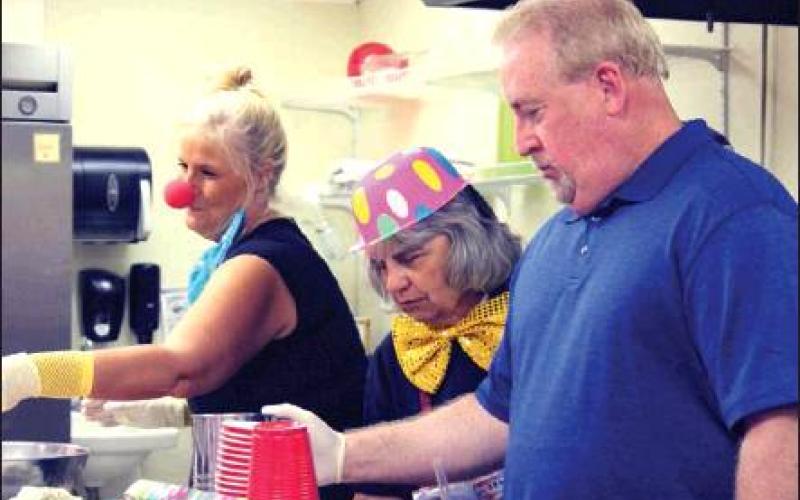 From left, Tina Bursby, Linda Crowder and Jay Copeland serve dinner.