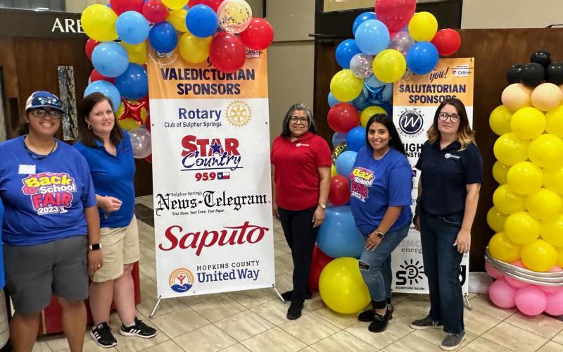 CANHelp team members Amanda Foster, Emily Crawford, Adela Martinez, Yanet Mejia and Christy Culpepper pose beside balloon towers recognizing two groups of sponsors.