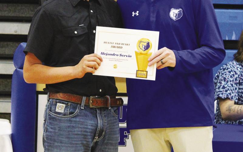 Coach Casey Riddle (right) presents Alejandro Servin with the Boys Heart and Hustle Award, given to the male athlete who brings unmatched energy, passion, selflessness and work ethic. Servin also earned the Boys Cross Country MVP Award.