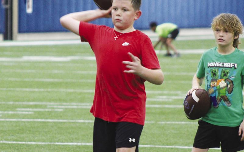 A camper throws the ball during a throwing drill at Wildcat Football Camp. Campers working on accurary by throwing balls into target nets. Staff Photos by DJ Spencer