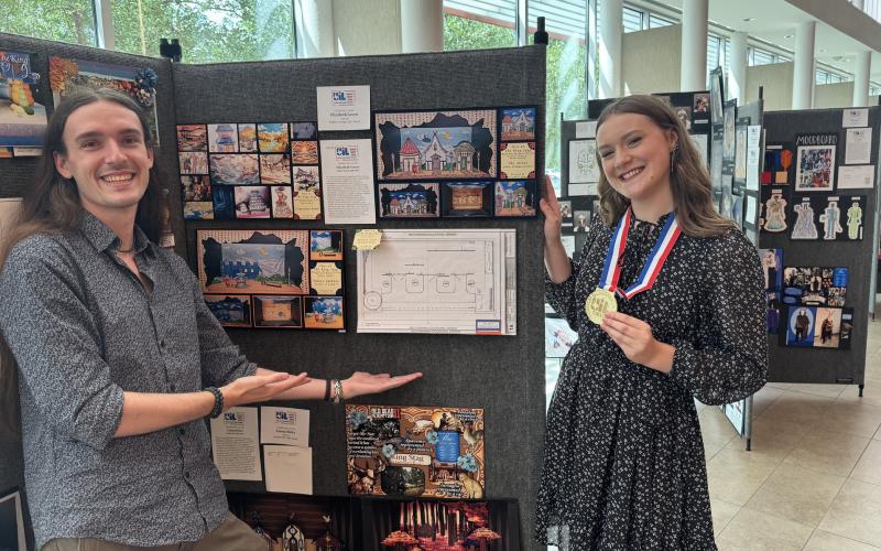 Coach Hagen Hunt shows off theatrical design state champion Elizabeth Green’s work.