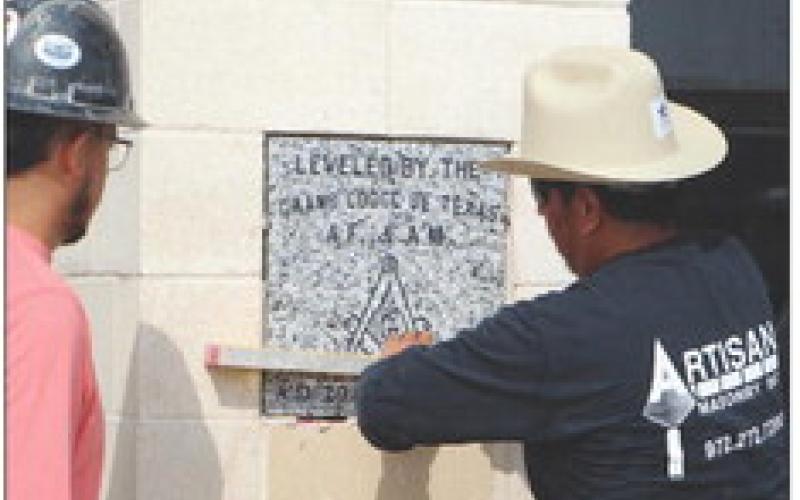 Workers from Arisan Masonry cement the cornrstone into place on one of the entry columns of the new Cumby Collegiate High School. Local and state Freemasons led the dedication ceremony for the new building, which is nearing completion. Staff photo by Tammy Vinson