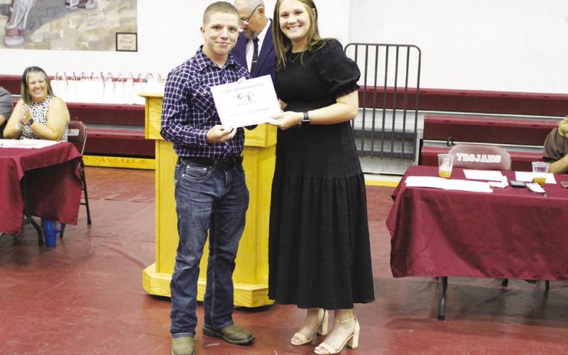 Adrian Radney (left) was named Boys Cross Country MVP at the Cumby Collegiate Athletic Banquet Tuesday. Presenting the award is Coach Macy Knickerbocker. Radney also earned the Boys Powerlifting MVP Award.