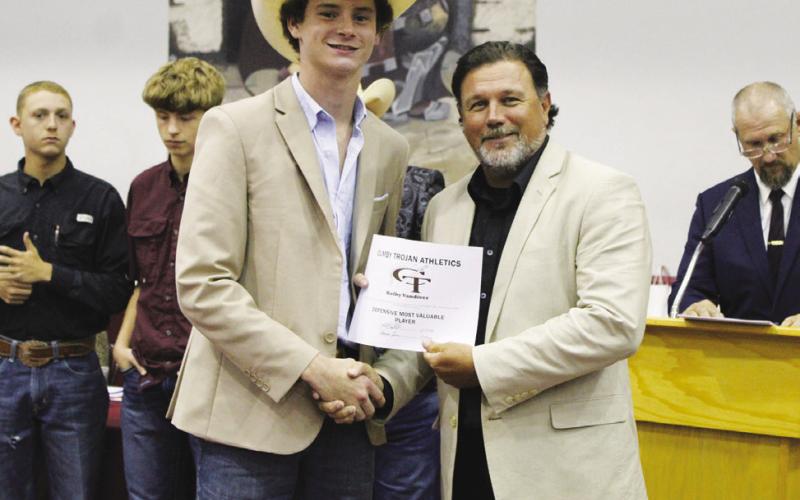 Kolby Vandiver (left) receieved the Football Defensive MVP Award at the Cumby Collegiate Athletic Banquet Tuesday. Presenting the award is Coach Aaron Emeyabbi.