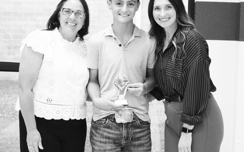 Danny James (center) was recognized as a Regional Qualifier in cross country and track and field at North Hopkins' Athletic Banquet Monday. Coaches Kara Callihan and Rosa Schones presented the award.
