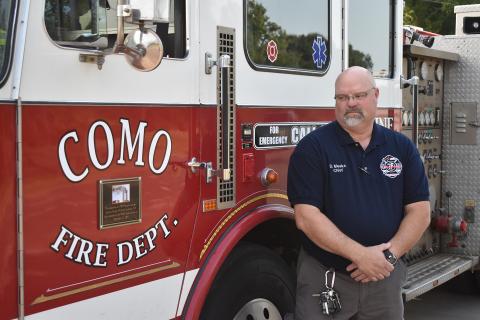 Como Volunteer Fire Department chief Darryl Meeks glances at a plaque detailing the truck behind him had responded to the World Trade Center on that fateful day.